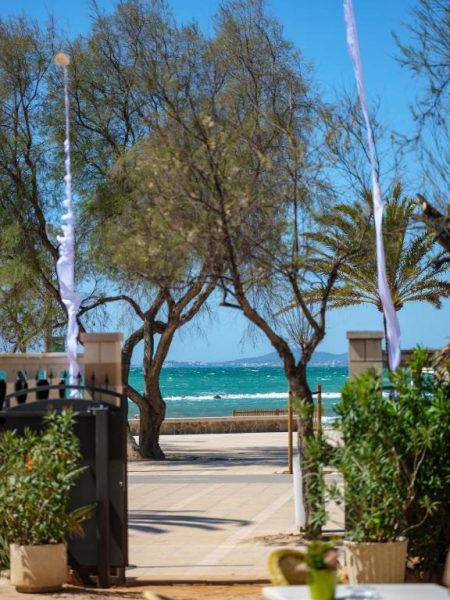 Paseo marítimo con vistas al mar turquesa desde el Hotel Ciutat Jardi en Mallorca