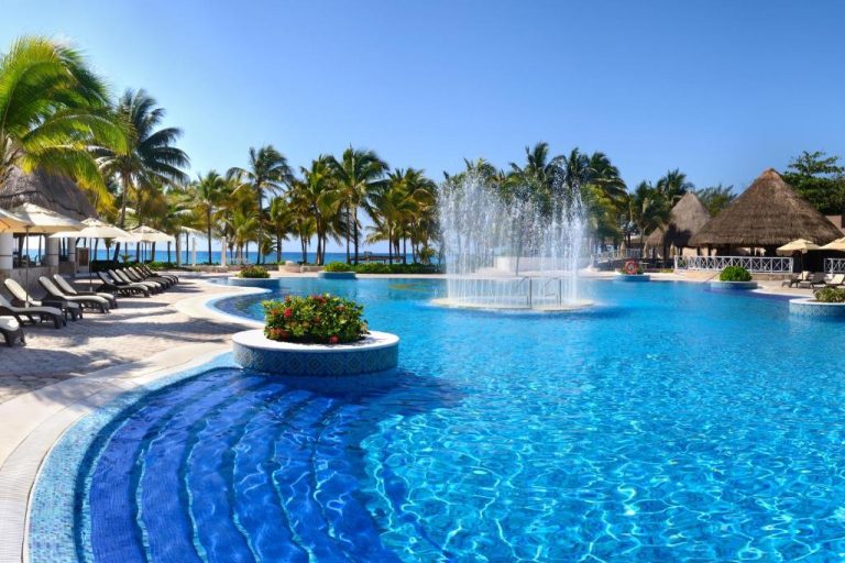Piscina exterior con fuente central y palmeras del Catalonia Royal Tulum Beach & Spa Resort Adults Only