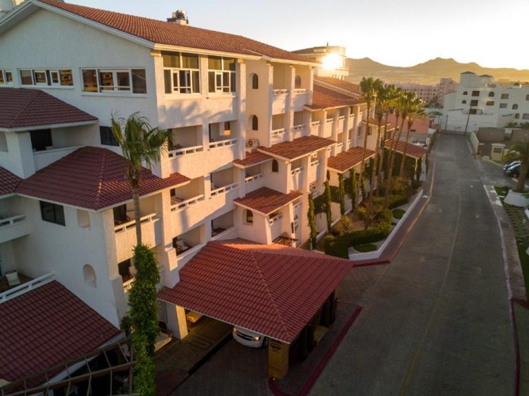 Vista aérea de la fachada exterior del Bahia Hotel & Beach House con palmeras y tejados rojos al atardecer