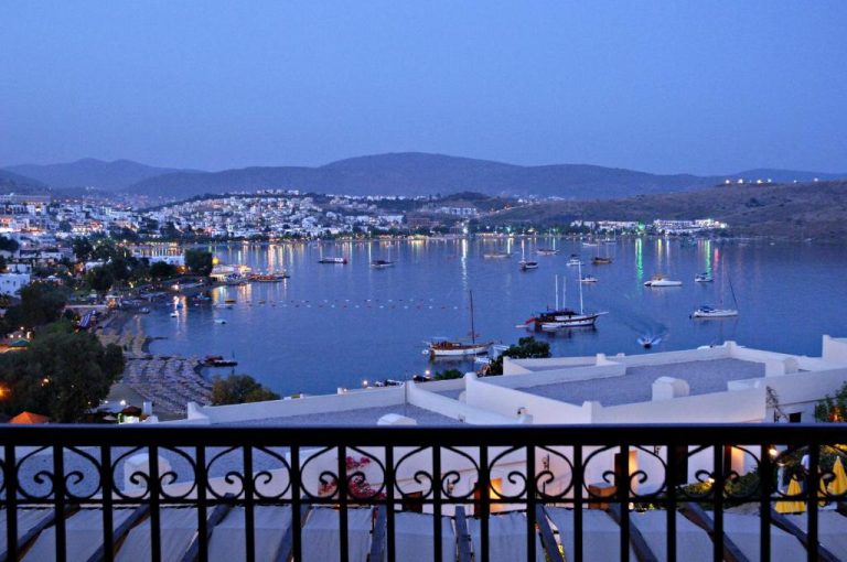 Vista nocturna de la bahía de Bodrum desde la terraza del hotel Selectum Colours Bodrum con veleros