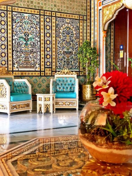 Lujoso lobby del Royal Victoria con sillones turquesa tallados y mosaicos artesanales de estilo oriental
