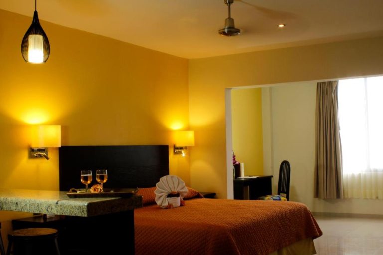 Habitación doble romántica con cama grande y copas de vino en Hotel Nautilus