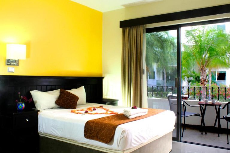 Habitación doble con decoración tropical y balcón con vistas a palmeras en Hotel Nautilus