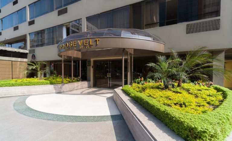 Entrada principal del Roosevelt Hotel & Suites con jardines tropicales y marquesina elegante