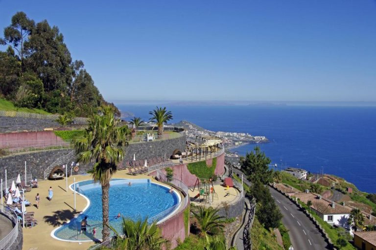 Piscina exterior con terraza y vistas al mar del Village Cabo Girao en Madeira