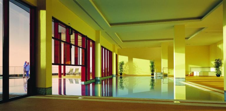 Piscina interior climatizada con luz natural y zona de relax del Village Cabo Girao