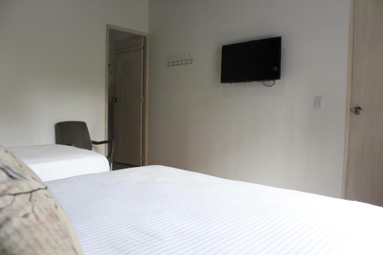 Habitación doble con dos camas y televisión de pared en Hotel Boutique Plaza