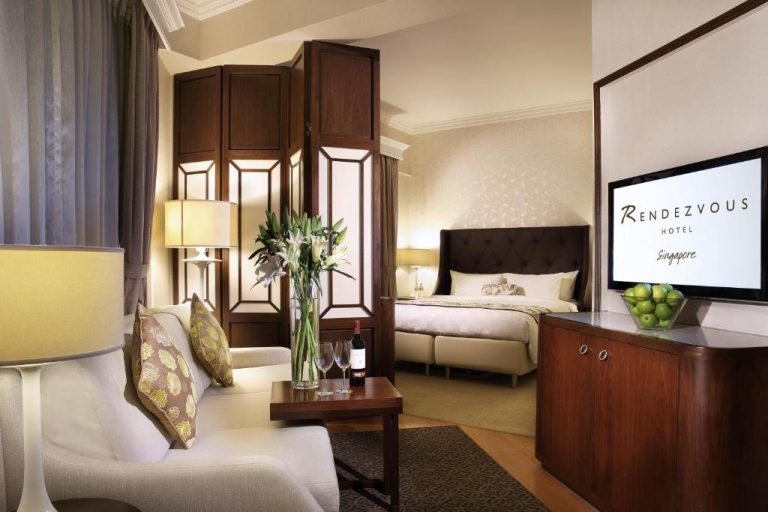 Suite con salón, cama doble y televisor en el Rendezvous Hotel Singapore by Far East Hospitality