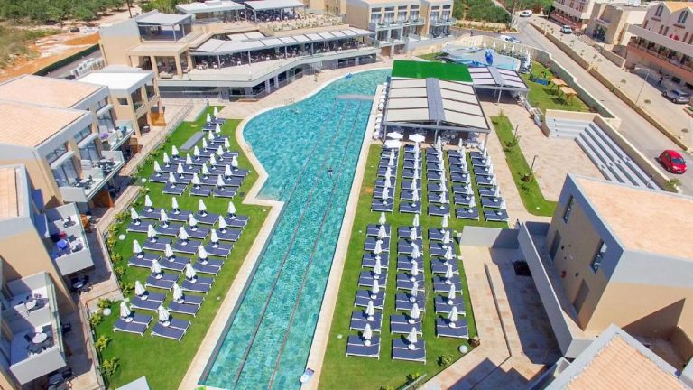 Vista aérea de la piscina exterior con tumbonas y sombrillas del Kiani Beach Resort Family All Inclusive