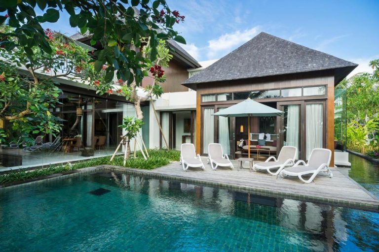 Villa con piscina privada y tumbonas en The Anvaya Beach Resort Bali rodeada de vegetación tropical