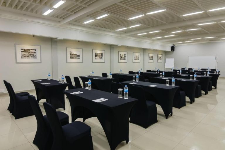 Sala de conferencias con mesas y sillas negras del Bali Garden Beach Resort lista para eventos