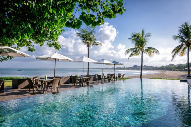 Piscina infinita con vistas al mar y zona de restaurante exterior del Bali Garden Beach Resort