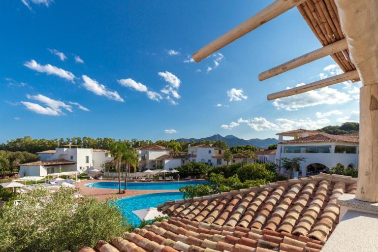 Vista aérea de la piscina exterior y villas blancas del resort Corte Bianca Adults Only & SPA de Bovis Hotels