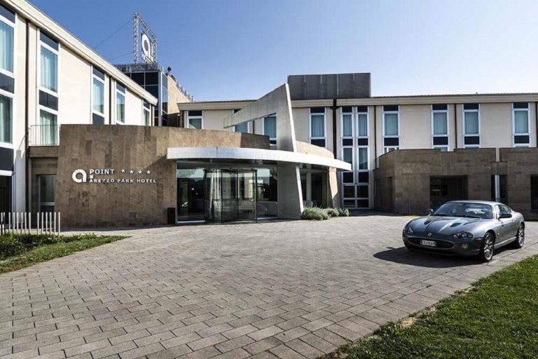 Fachada principal con entrada moderna y deportivo del A Point Arezzo Park Hotel de cuatro estrellas
