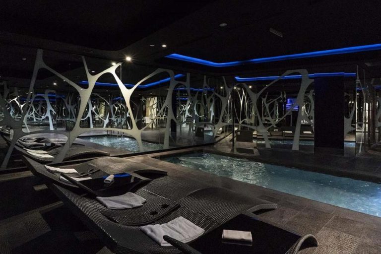 Zona spa con piscina interior y tumbonas de diseño en A Point Arezzo Park Hotel