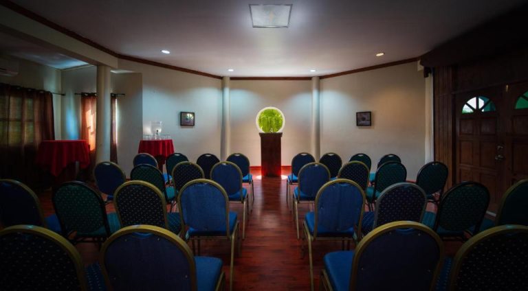 Sala de conferencias con sillas azules y decoración elegante en Toby's Resort para eventos y reuniones