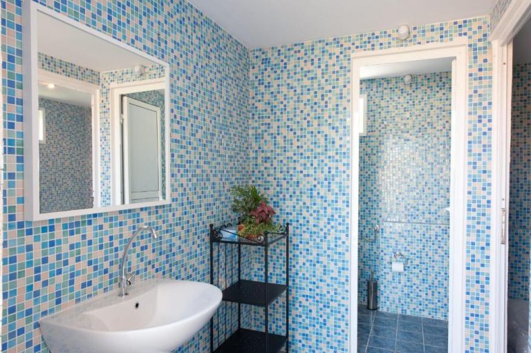 Baño con azulejos de mosaico azul y ducha en Marina Apartments Agios Gordios Corfú