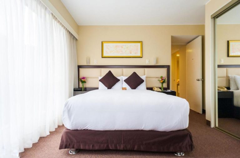 Habitación con cama king size y decoración elegante en el Roosevelt Hotel & Suites