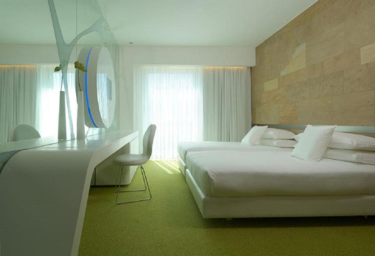 Habitación doble moderna con moqueta verde y decoración minimalista en A Point Arezzo Park Hotel