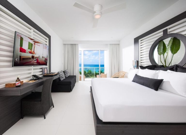 Habitación de lujo con cama doble, TV y vista al mar turquesa en S Hotel Montego Bay