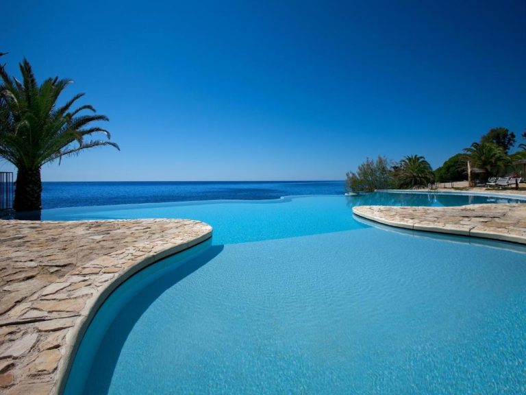 Piscina infinita con vistas al mar Mediterráneo del Hotel Costa dei Fiori rodeada de palmeras
