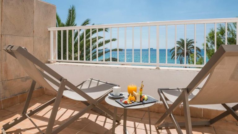 Terraza con tumbonas y desayuno con vistas al mar en Be Live Adults Only La Cala Boutique Hotel
