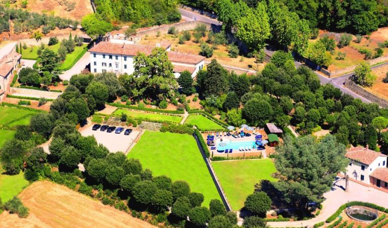 Vista aérea del Cortona Resort & Spa con piscina exterior, jardines y villa toscana