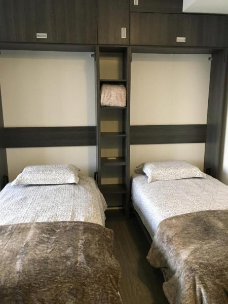 Habitación twin con dos camas individuales y armario empotrado de madera en Enjoy In Bogotá