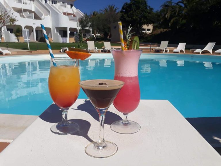 Tres cócteles tropicales junto a la piscina exterior del Hotel Vilamar en un día soleado