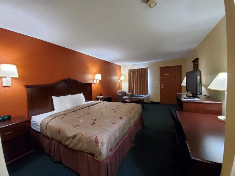 Habitación con cama doble, televisión y escritorio en el Cuba Inn Hotel