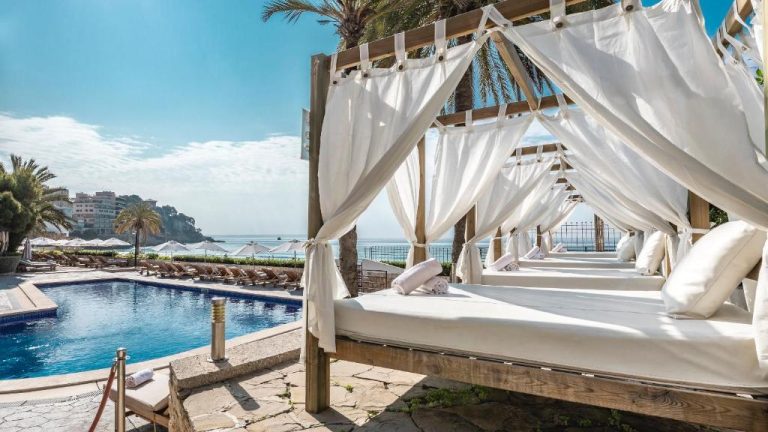 Lujosas camas balinesas con dosel blanco junto a la piscina del Be Live Adults Only La Cala Boutique Hotel