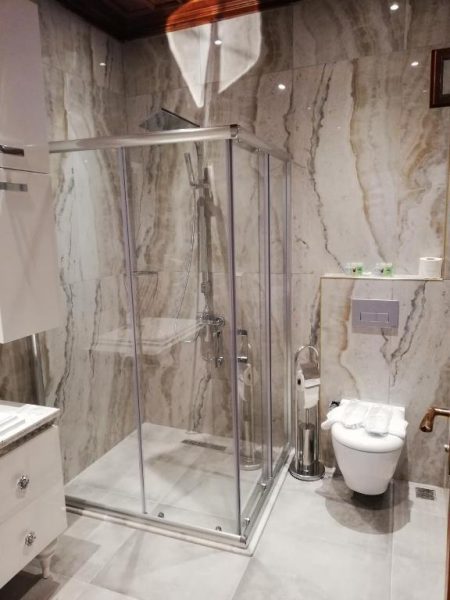 Baño de lujo con ducha de cristal y paredes de mármol en White Garden Hotel Adult Only