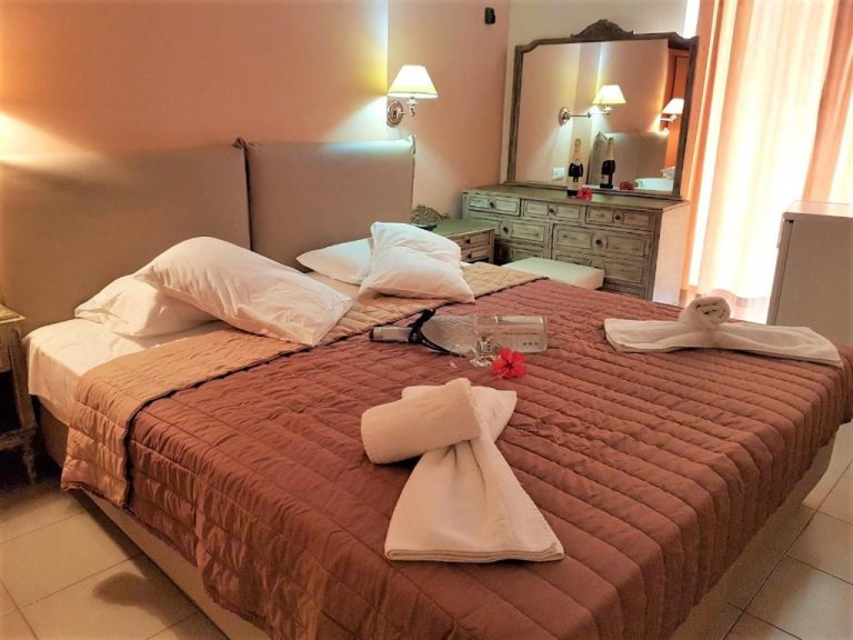 Habitación doble con cama matrimonial y toallas decoradas en Mitho Hotel Spa