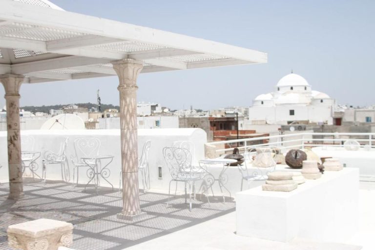 Terraza con sillas de hierro blanco y vistas a la medina en Dar Ben Gacem Kahia, Túnez