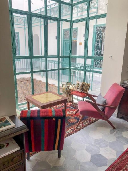 Salón tradicional con sillones vintage y patio interior en Dar Ben Gacem Kahia con celosías turquesas