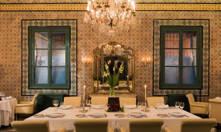 Elegante salón privado del restaurante Dar El Jeld Hotel and Spa con azulejos tradicionales y araña de cristal