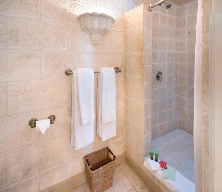 Baño con ducha de piedra natural y toallas blancas en Little Arches Boutique Hotel Adults Only