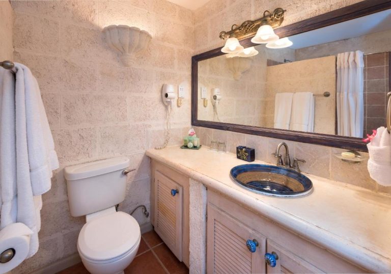 Baño elegante con lavabo azul artesanal y paredes de piedra en Little Arches Boutique Hotel Adults Only