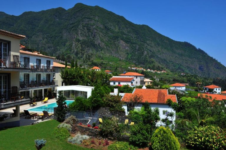Piscina exterior con vistas a la montaña verde en el hotel Estalagem do Vale en Madeira