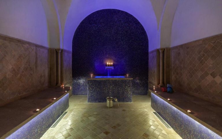 Hammam tradicional con mosaicos azules y velas del Dar El Jeld Hotel and Spa en Túnez