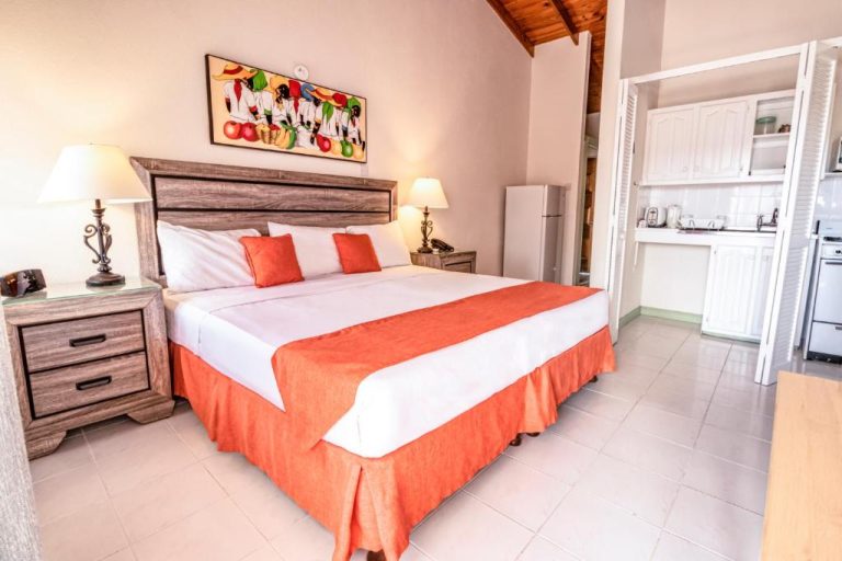 Habitación con cama king size y cocina equipada en Worthing Court Apartment Hotel Barbados