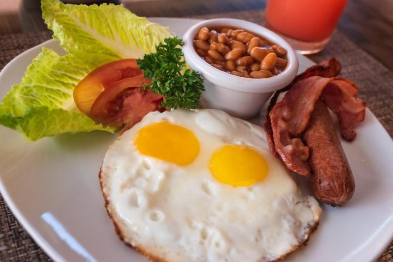 Desayuno completo con huevos fritos, bacon, salchichas y alubias en Worthing Court Apartment Hotel