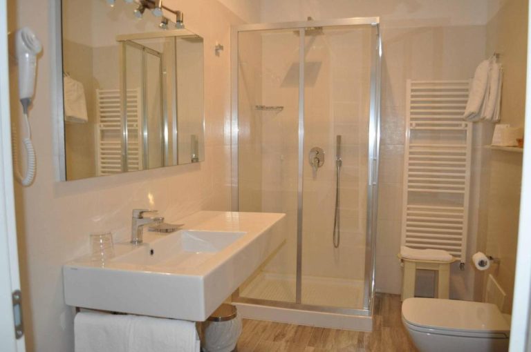 Baño moderno con ducha de cristal, lavabo y toallero del Hotel Boncardo