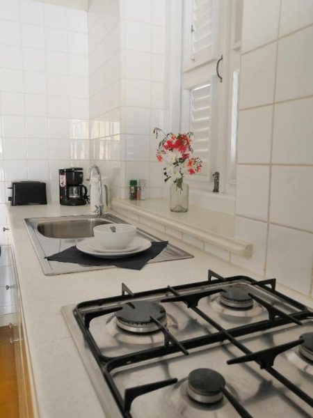 Cocina equipada con vitrocerámica y fregadero del Landhuis Klein Santa Martha Boutique Hotel Restaurant