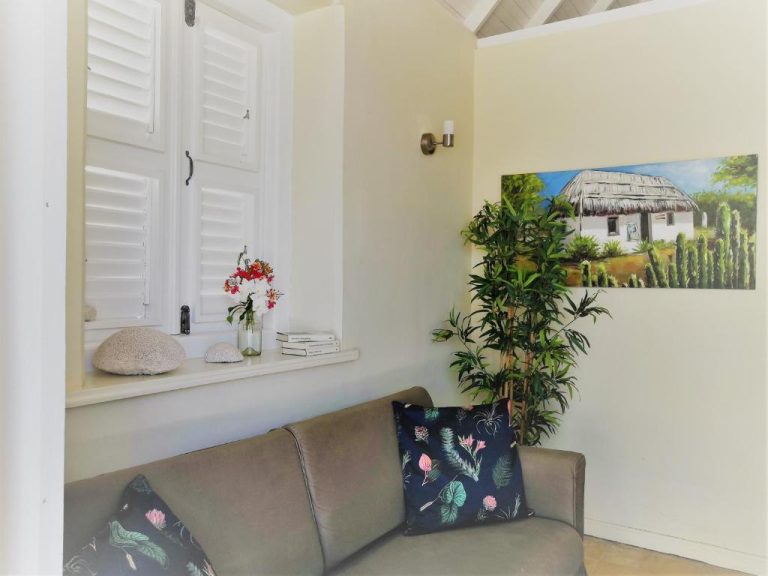 Sala de estar con sofá y decoración tropical en Landhuis Klein Santa Martha Boutique Hotel Restaurant