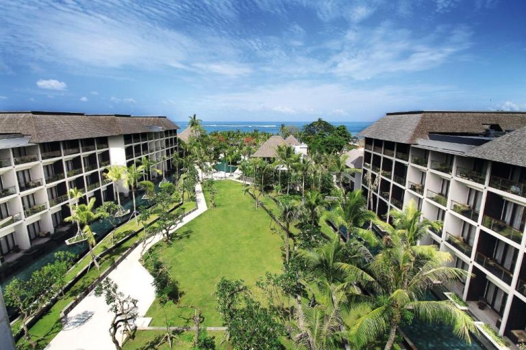Vista aérea de los jardines tropicales y edificios del The Anvaya Beach Resort Bali con vistas al mar