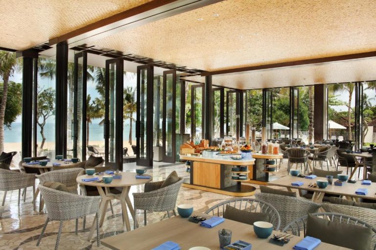 Restaurante con vistas a la playa y palmeras del The Anvaya Beach Resort Bali