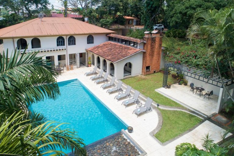 Piscina exterior con tumbonas y jardín tropical del Hotel Villa San Ignacio en Costa Rica