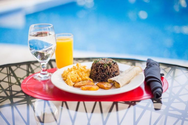 Desayuno típico costarricense con gallo pinto, huevos y plátanos en Villa San Ignacio junto a la piscina