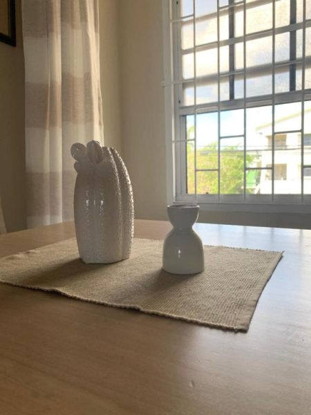 Mesa de comedor con decoración de jarrones blancos de cerámica en Beach Vue Barbados